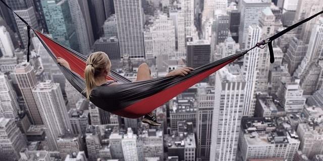 Frau in Hängematte über Hochhäusern
